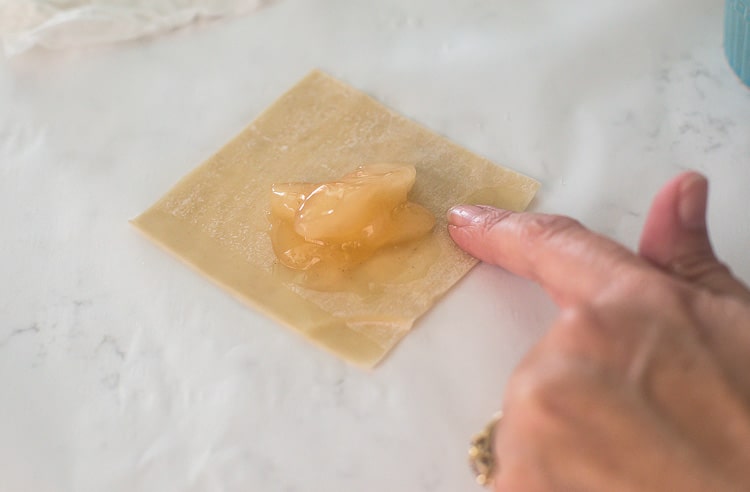 Apple Pie Wontons with cinnamon sugar and powdered sugar Putting water along edge of wonton wrapper