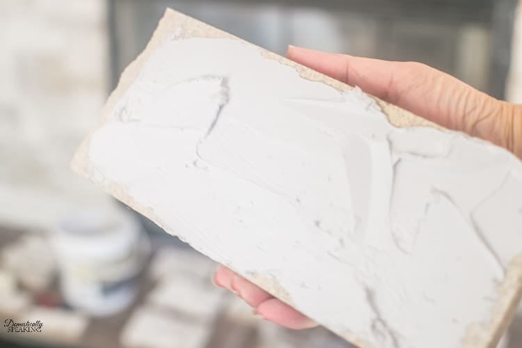 Adding the adhesive to the back of the faux stone. Adding the adhesive to the back of the faux stone.