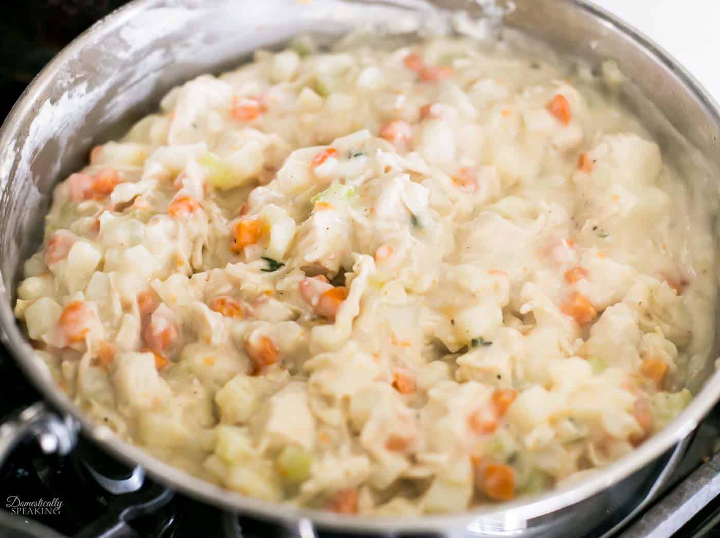 Adding chicken to the creamy filling for the rustic chicken pot pie. Adding chicken to the creamy filling for the rustic chicken pot pie.
