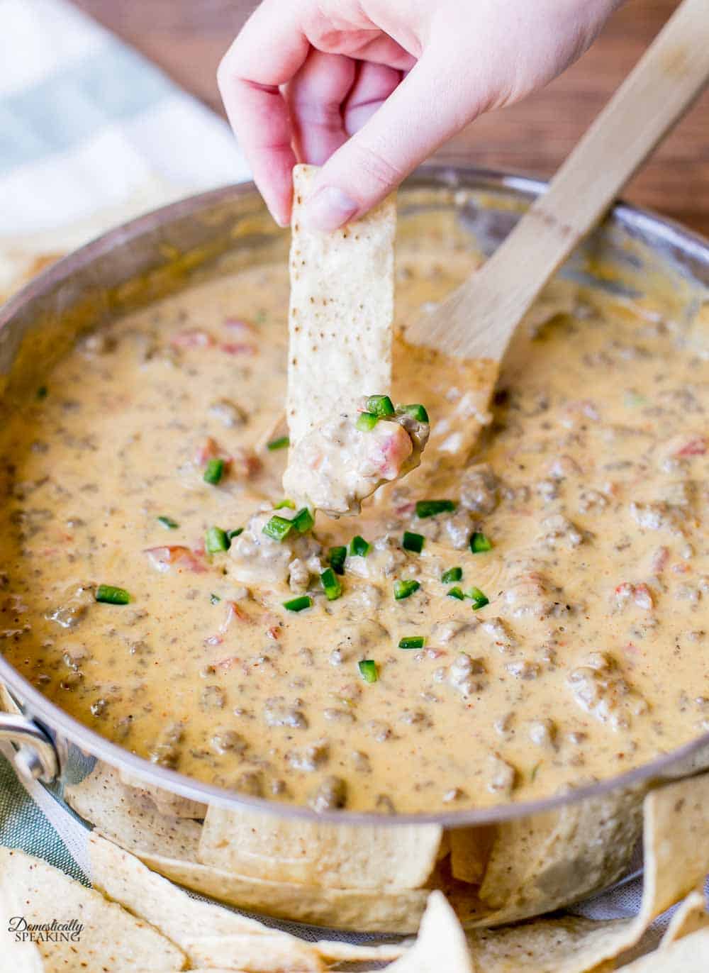 Loading up a chip with the Hot Cheesy Beef Dip