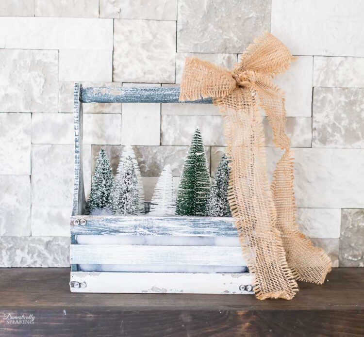 Christmas Farmhouse Toolbox with faux snow, mini trees, and burlap ribbon.