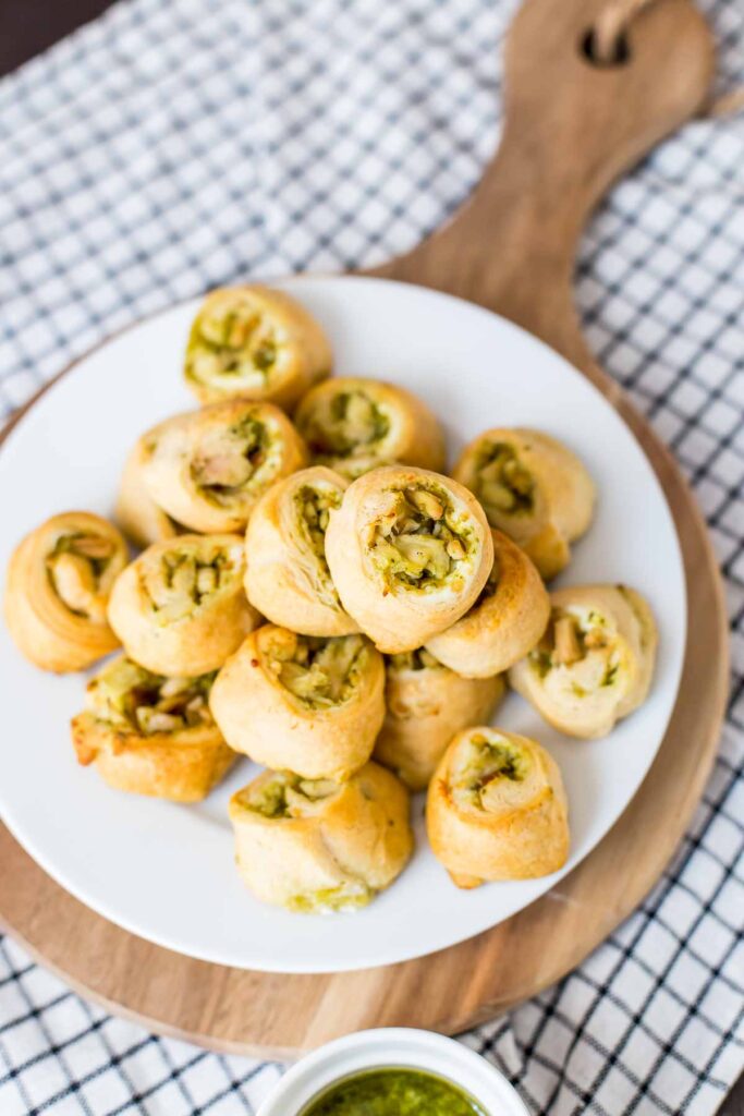 pesto chicken pinwheels piled up on a plate