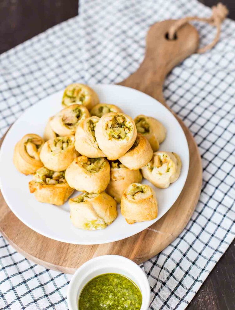 easy chicken pinwheel appetizer with cream cheese, pesto, and chicken wrapped in a crescent roll.