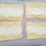 Cream cheese spread over the crescent dough