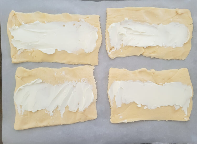 Cream cheese spread over the crescent dough