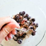 Combing frozen cherries with sugar, flour, and vanilla for filling for cherry crisp