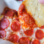 dipping toasted bread into pizza dip