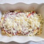 adding mozzarella and Parmesan cheese on top of pizza sauce