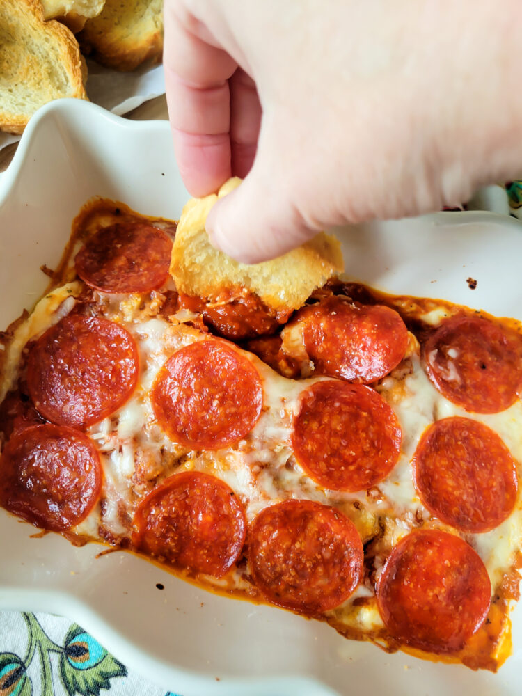 toasted bread dipping in the hot pizza dip